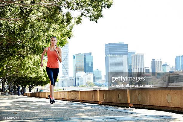 young woman runs near the city - brisbane city foto e immagini stock