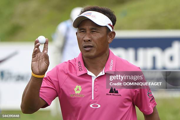 Thailand's Thongchai Jaidee holds a golf ball after winning the 100th French Golf Open on July 3, 2016 at Le Golf National in Guyancourt, near Paris....