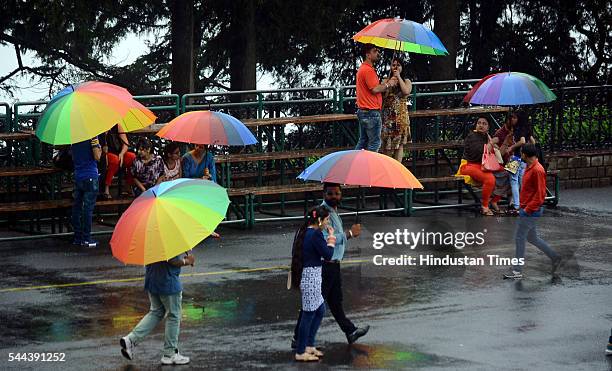 People enjoy walking with colourful umbrellas in the pleasant weather during rain at Ridge, on July 2 2016 in Shimla, India. The minimum temperature...