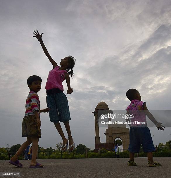 Children enjoy pleasant weather after the pre-monsoon shower at India Gate, on July 2, 2016 in New Delhi, India. On Saturday, the maximum temperature...