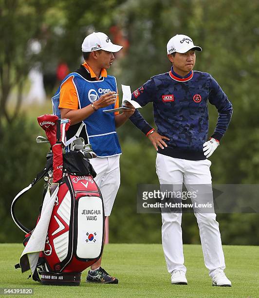 Jeunghun Wang of Korea looks on with his caddie during day four of the 100th Open de France at Le Golf National on July 3, 2016 in Paris, France.
