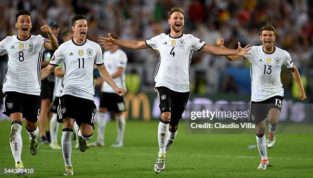 Germany players dash to celebrate their win through the penalty shootout after Jonas Hector scores to win the game after the UEFA EURO 2016 quarter...