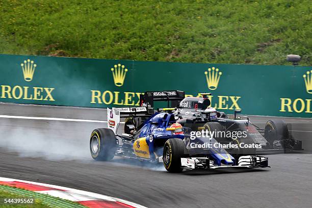 Felipe Nasr of Brazil driving the Sauber F1 Team Sauber C35 Ferrari 059/5 turbo locks a wheel next to Jenson Button of Great Britain driving the...