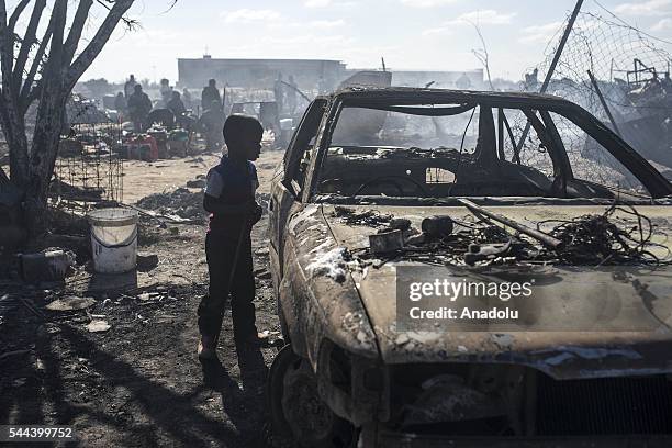 Residents of the Plastic View informal settlement collects usable household goods after a huge fire destroyed over 200 homes in the slum area, east...