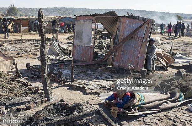 Residents of the Plastic View informal settlement collects usable household goods after a huge fire destroyed over 200 homes in the slum area, east...