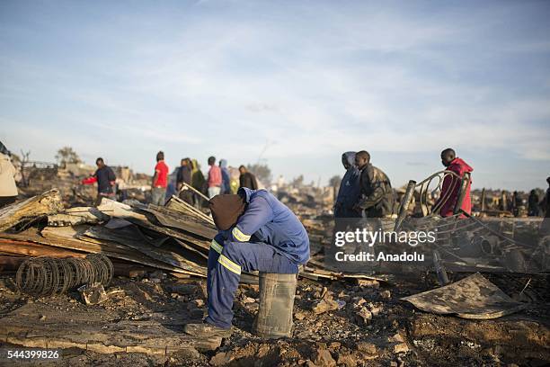 Residents of the Plastic View informal settlement collects usable household goods after a huge fire destroyed over 200 homes in the slum area, east...