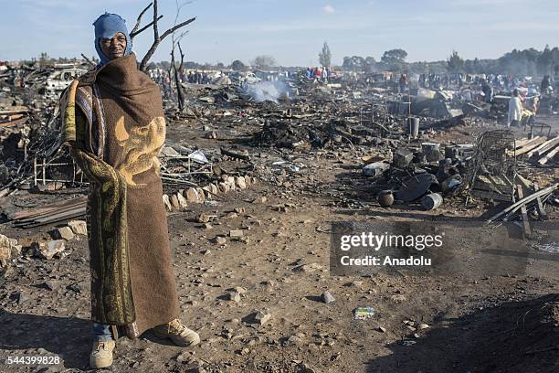 Residents of the Plastic View informal settlement collects usable household goods after a huge fire destroyed over 200 homes in the slum area, east...