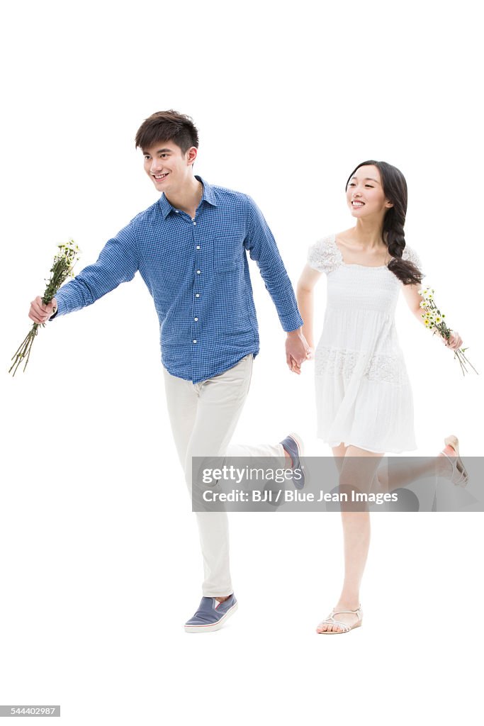 Happy young couple running with flowers