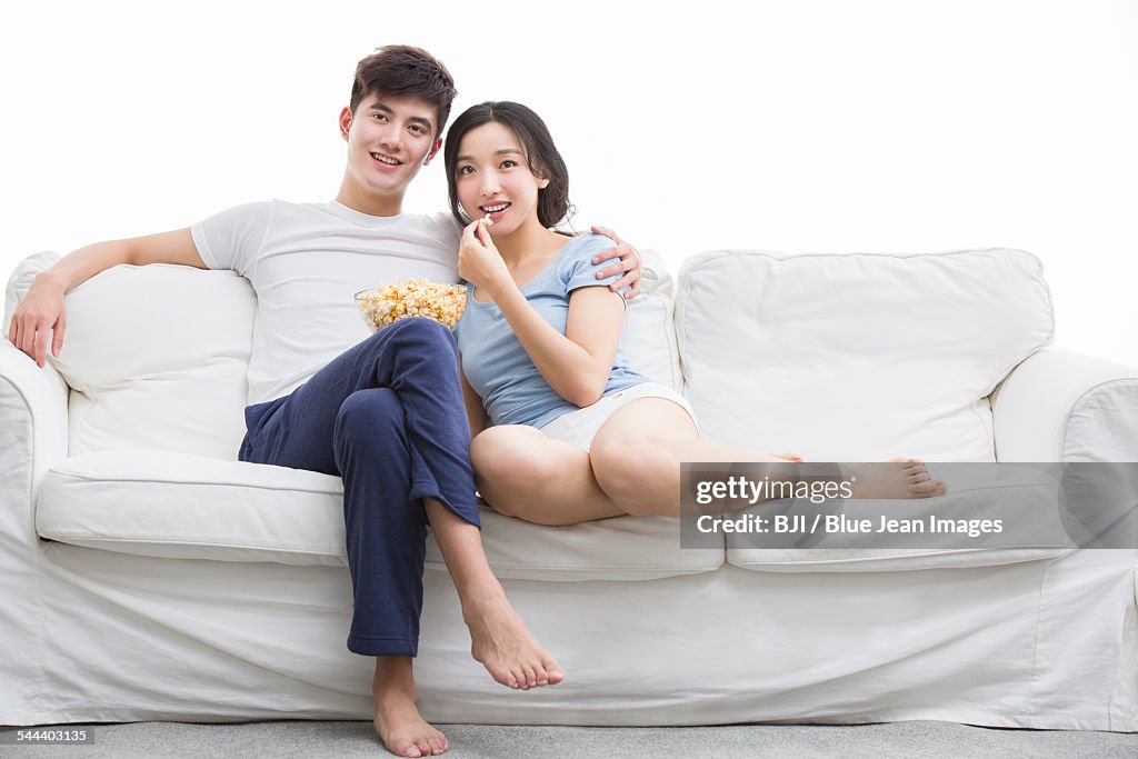 Young couple watching movie in living room