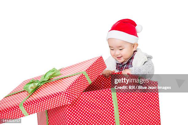 cute baby unwrapping christmas gift - unwrapped stock pictures, royalty-free photos & images