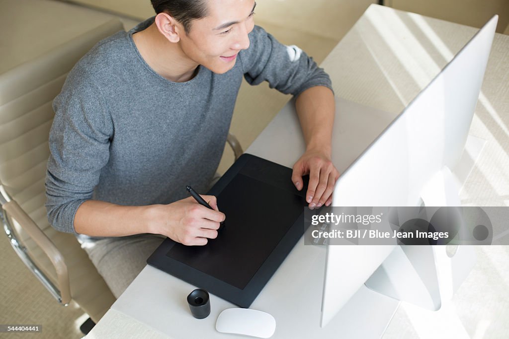 Young male fashion designer working at home