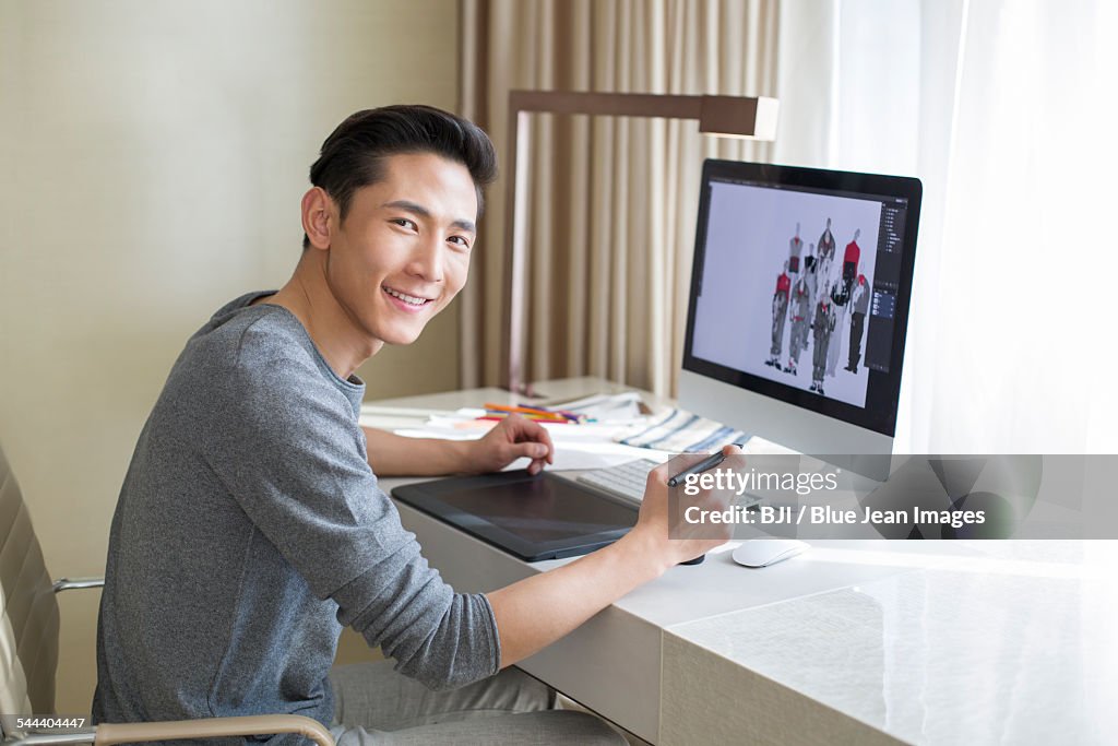 Young male fashion designer working at home