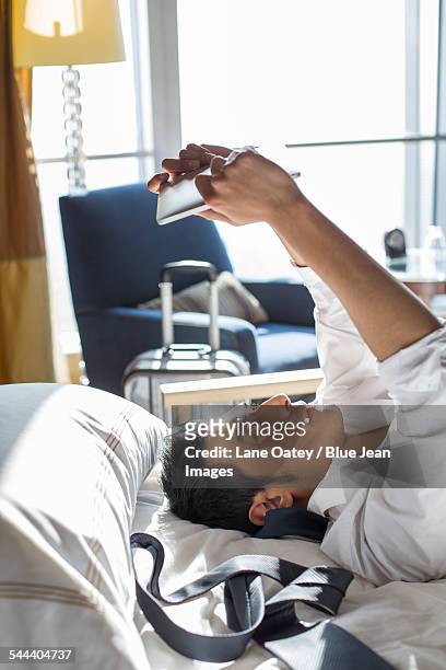young businessman using digital tablet in hotel room - man in suite holding tablet stockfoto's en -beelden