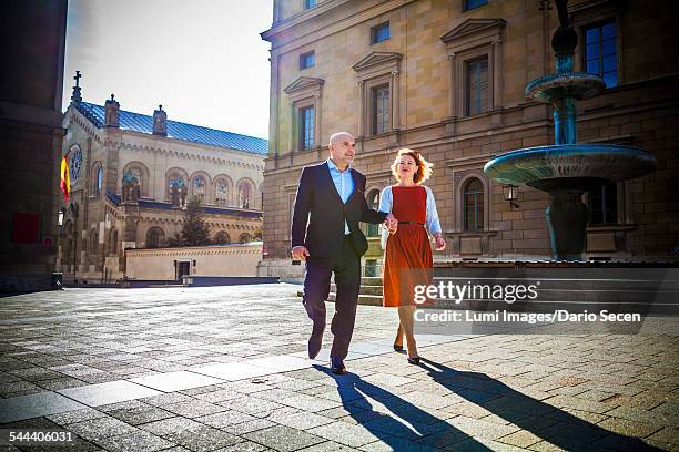 senior couple walking in town, munich, bavaria, germany - anzug ausland stock-fotos und bilder