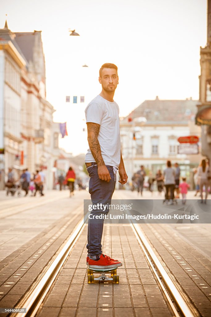 Young man skateboarding on city street