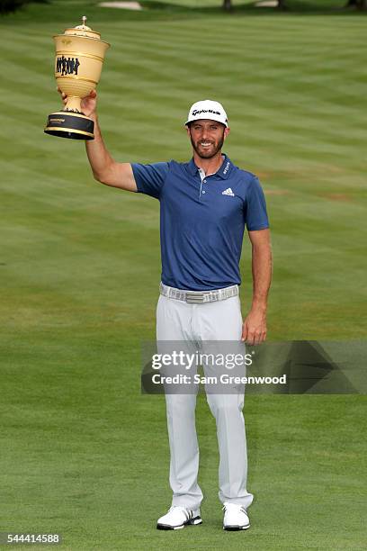 Dustin Johnson holds the Gary Player Cup after winning the World Golf Championships - Bridgestone Invitational during the final round at Firestone...