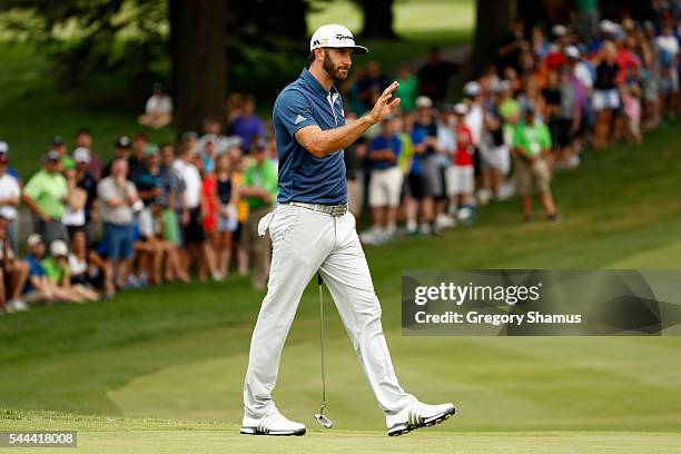 Dustin Johnson reacts on the 18th green after a putt during the final round of the World Golf Championships - Bridgestone Invitational at Firestone...
