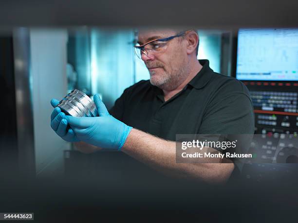 portrait of engineer holding engineered part at cnc machine in factory - cnc stock pictures, royalty-free photos & images