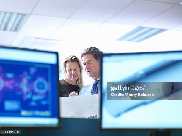 female and male engineer designers discussing plans in office - engineer cad photos et images de collection