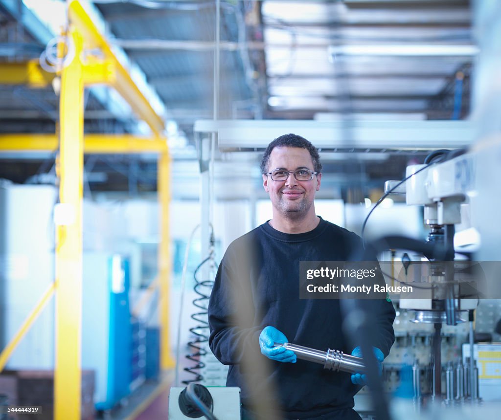 Portrait of engineer holding part in factory