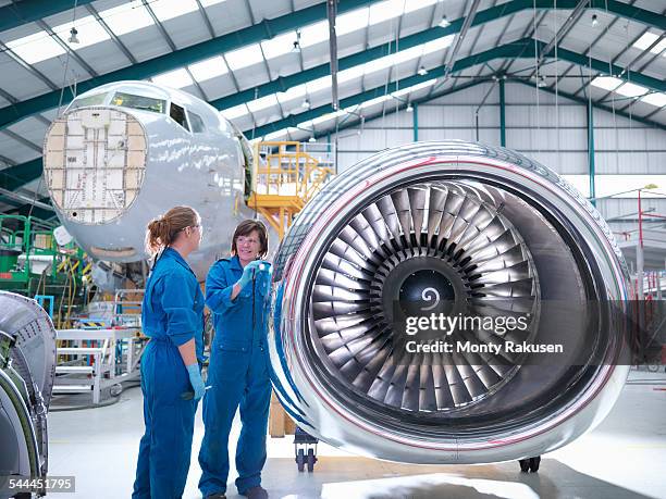 female engineers working on engine in aircraft maintenance factory - aircraft engineer stock-fotos und bilder