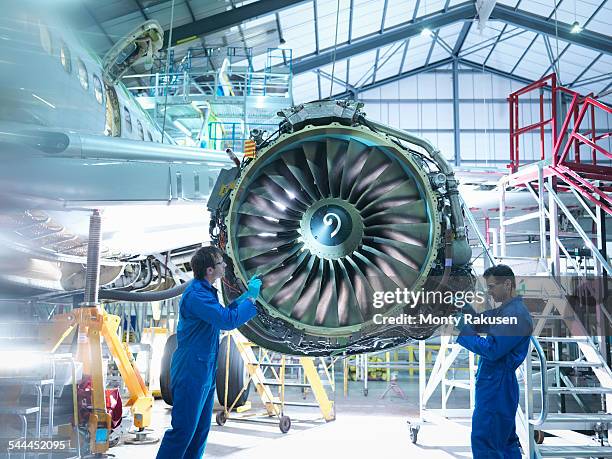 aircraft engineers working on jet engine in aircraft maintenance factory - jet engine stock pictures, royalty-free photos & images