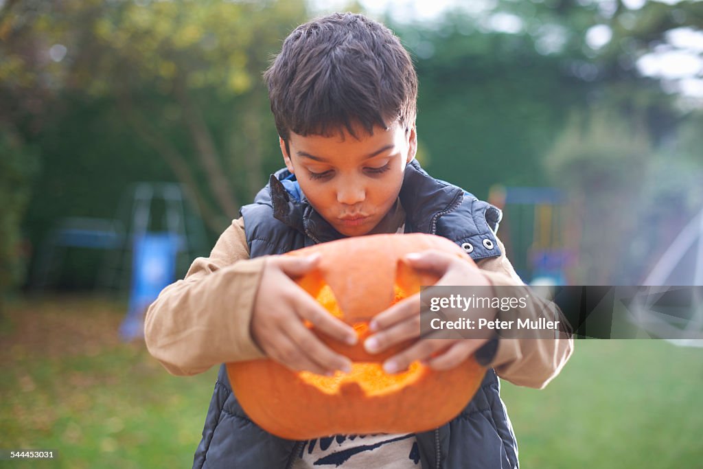 Boy with pumpkin posing in garden
