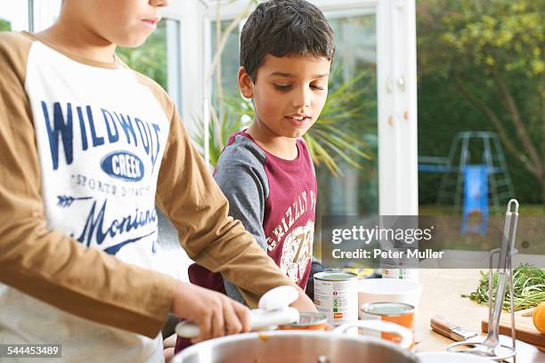 cropped shot of boys opening tin of tomato soup - can opener stock pictures, royalty-free photos & images