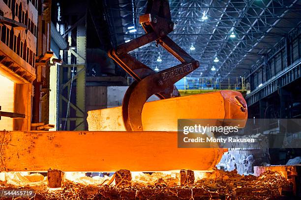 red hot steel in steelworks - ijzer stockfoto's en -beelden
