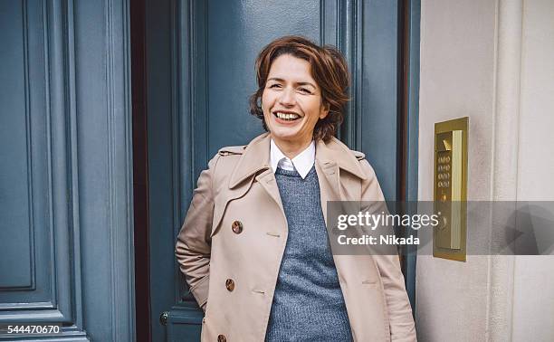 smart fashionable woman stepping outdoors - french women stock pictures, royalty-free photos & images