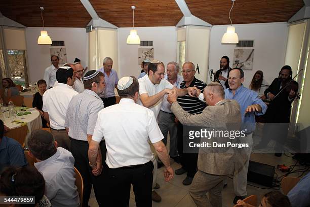 At an Orthodox Jewish wedding, guests surround the groom's father and brother as they dance, Jerusalem, Israel, August 29, 2014.