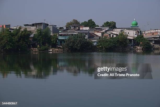 reflection of slum area in jakarta - jakarta slum stock pictures, royalty-free photos & images