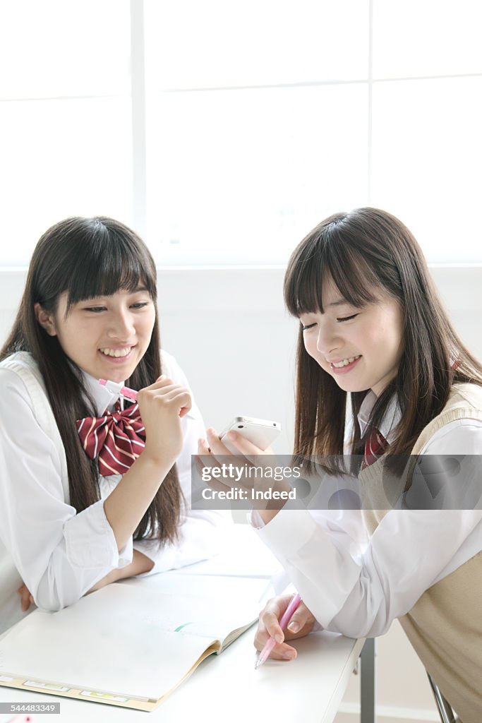 Two teenage girls using a mobile