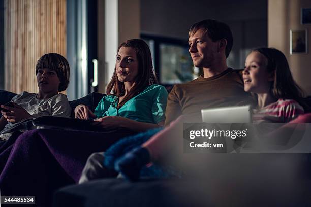 familie vor dem fernseher zu abend - filmabend stock-fotos und bilder