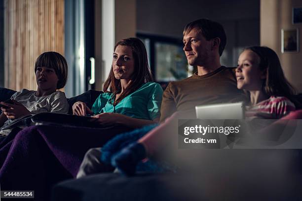 family watching television in the evening - watching tv couple night stock pictures, royalty-free photos & images