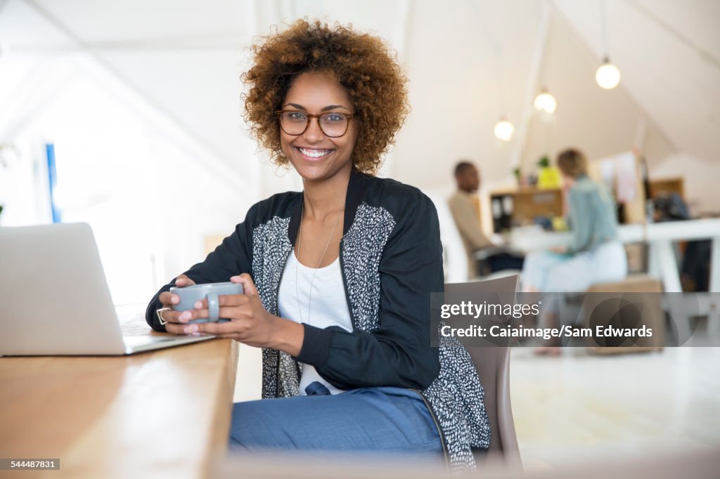 Office worker with coffee using laptop