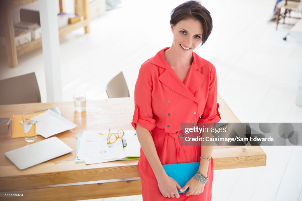 Portrait of businesswoman wearing red dress,smiling in office