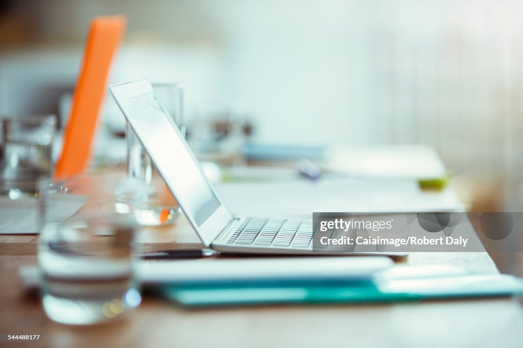 Bürobedarf, Laptop und Glas Wasser auf dem Schreibtisch im Büro