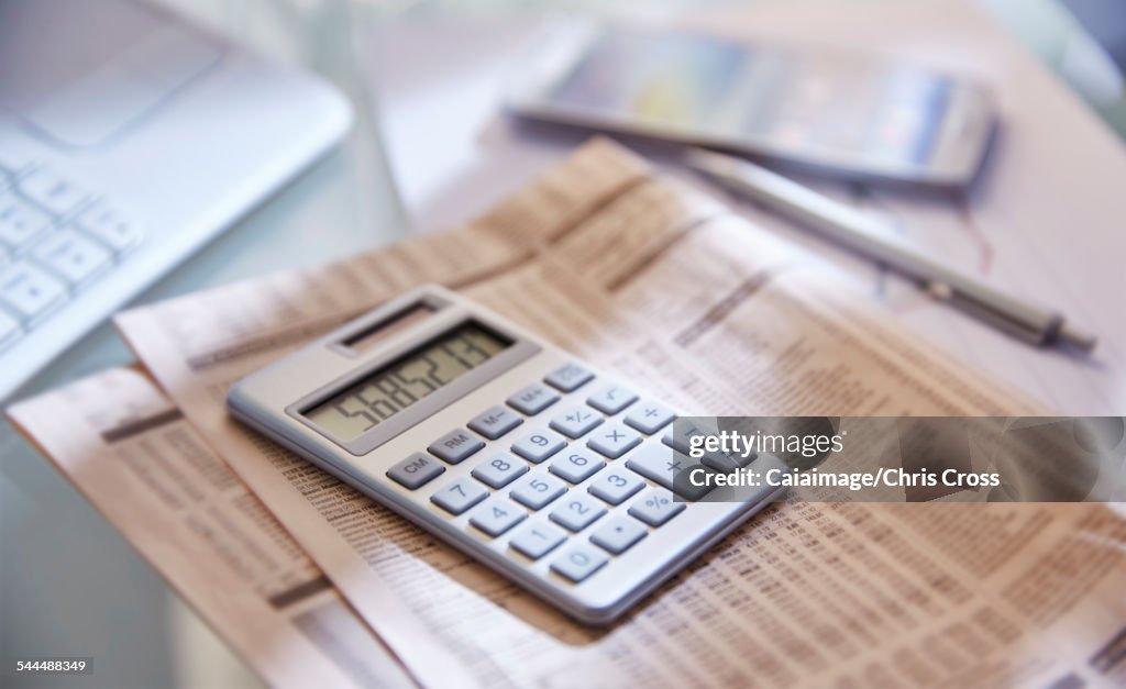 Calculator,close up,newspaper and pen on desk