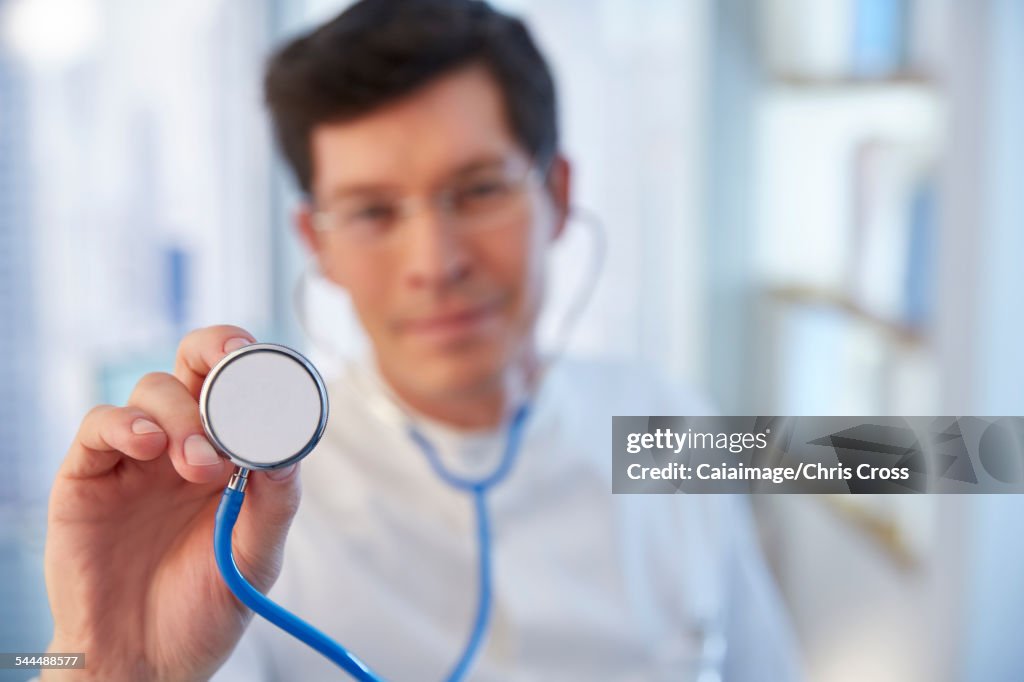 Man reaching towards camera with stethoscope in laboratory