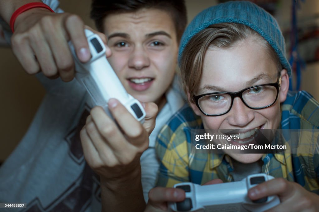 Two teenage boys playing together video game