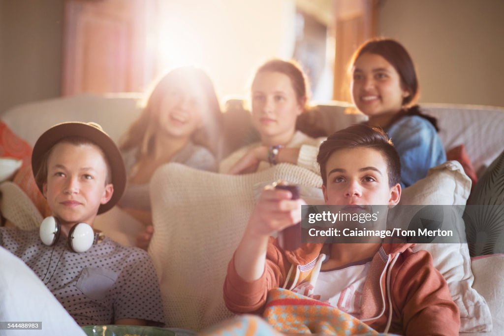 Groupe d’adolescents regardant la télévision sur le canapé ensemble
