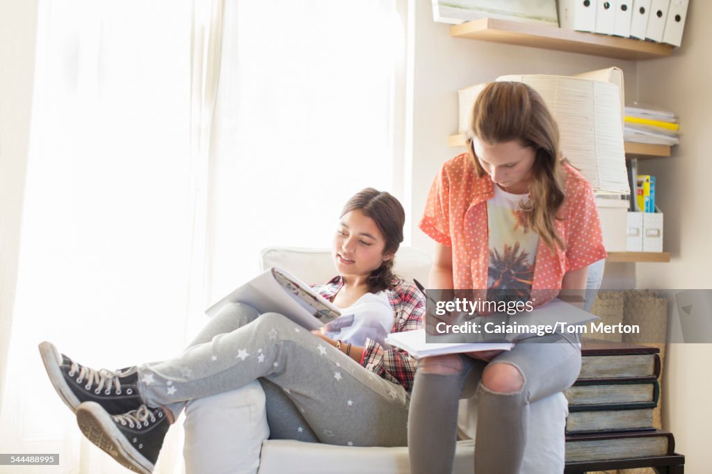 Zwei Mädchen im Teenageralter machen Hausaufgaben im Zimmer