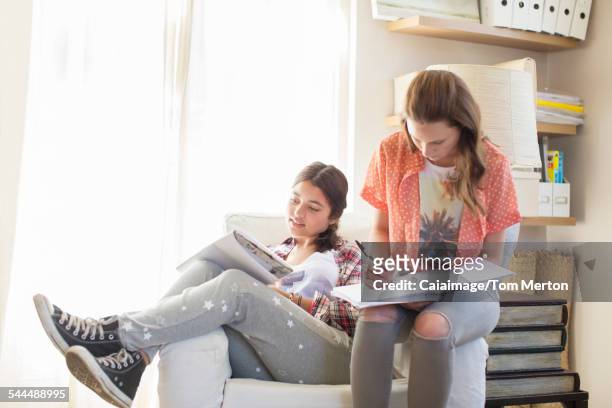 Two teenage girls doing homework in room