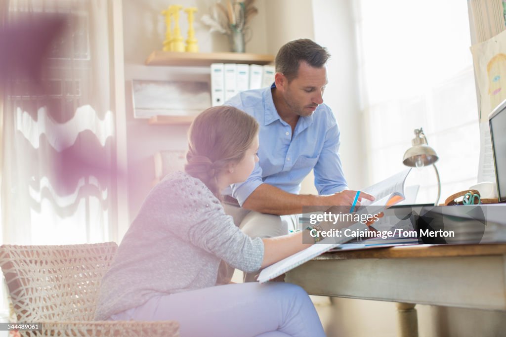 Father helping teenage daughter with her homework