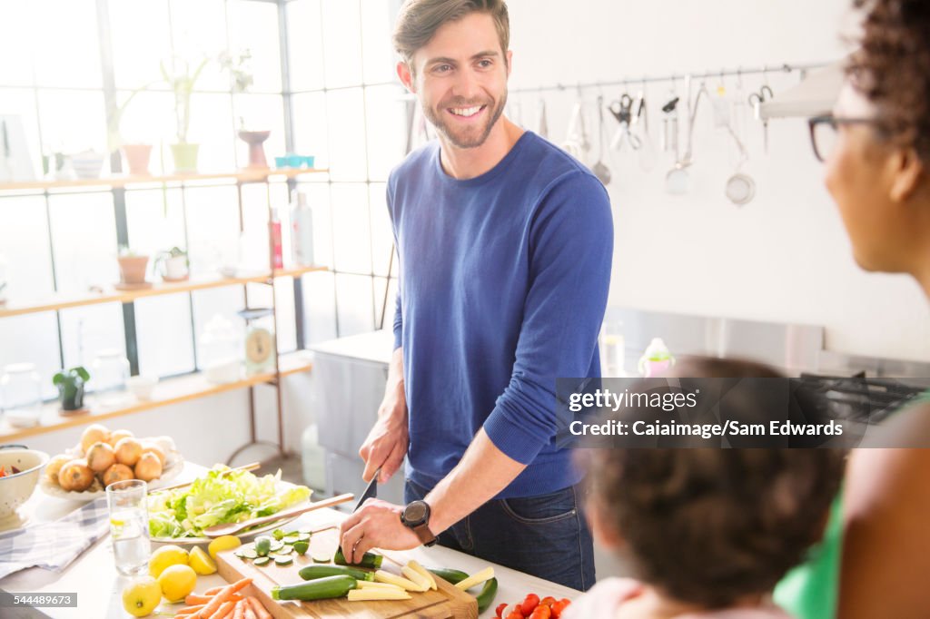 Happy family preparing meal in domestic kitchen