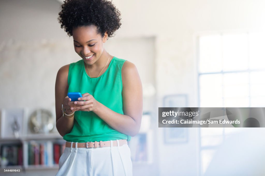 Portrait of woman with black curly hair holding mobile phone