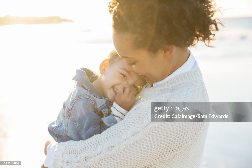 Jeune femme embrassant sa fille sur la plage