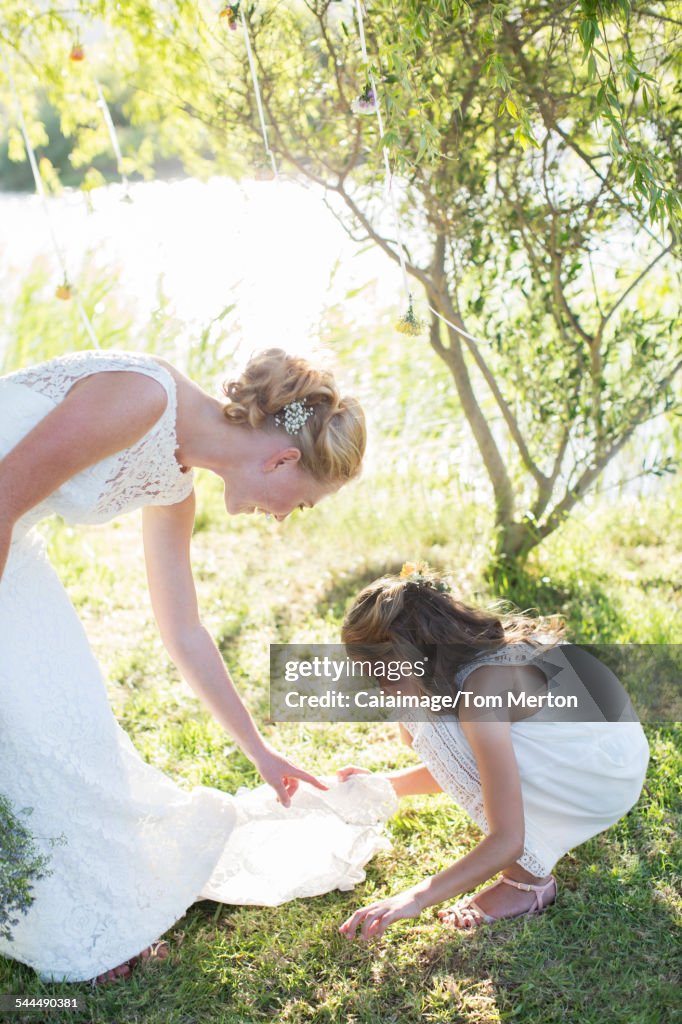 Bride and bridesmaid in domestic garden during wedding reception