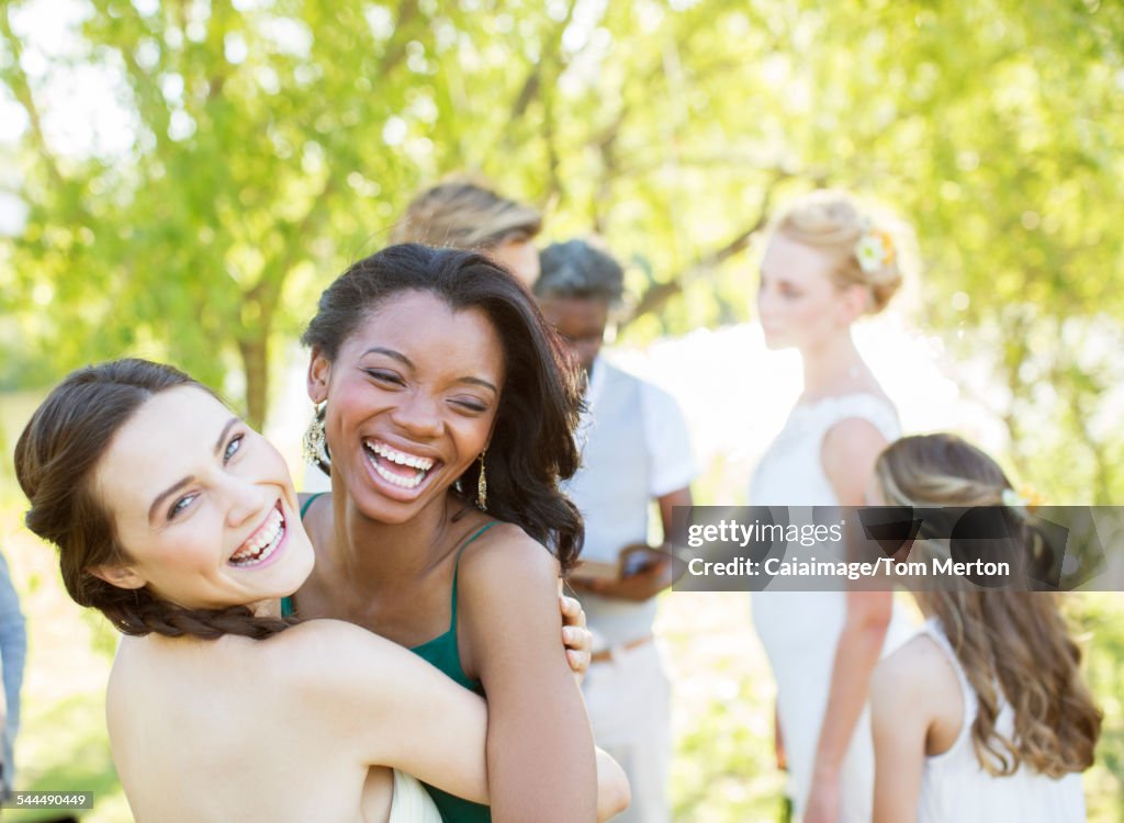 Bridesmaid and friend dancing during wedding reception in domestic garden